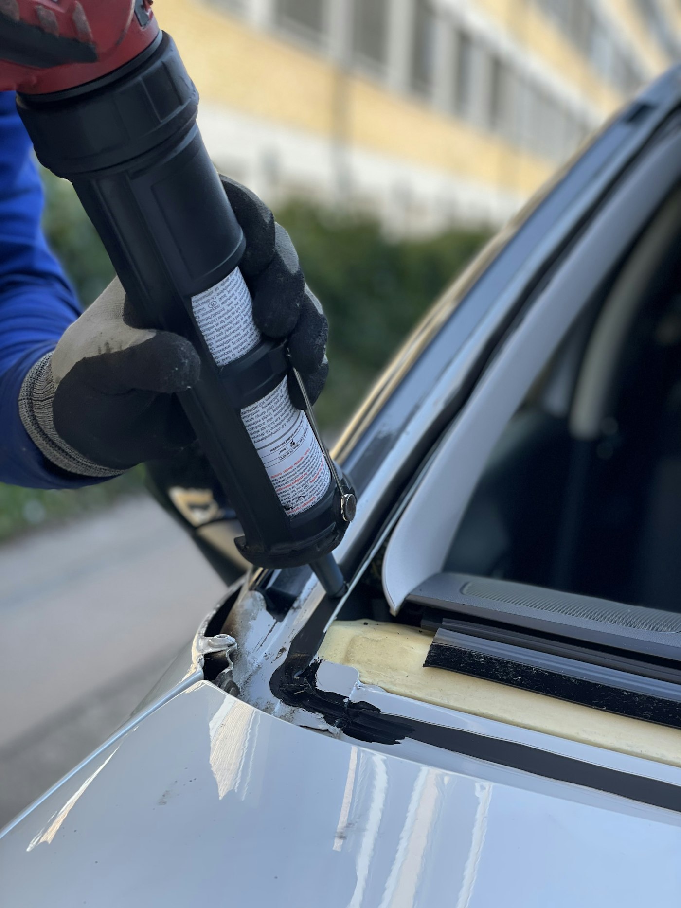 Technician applying chip repair resin to a damaged windshield